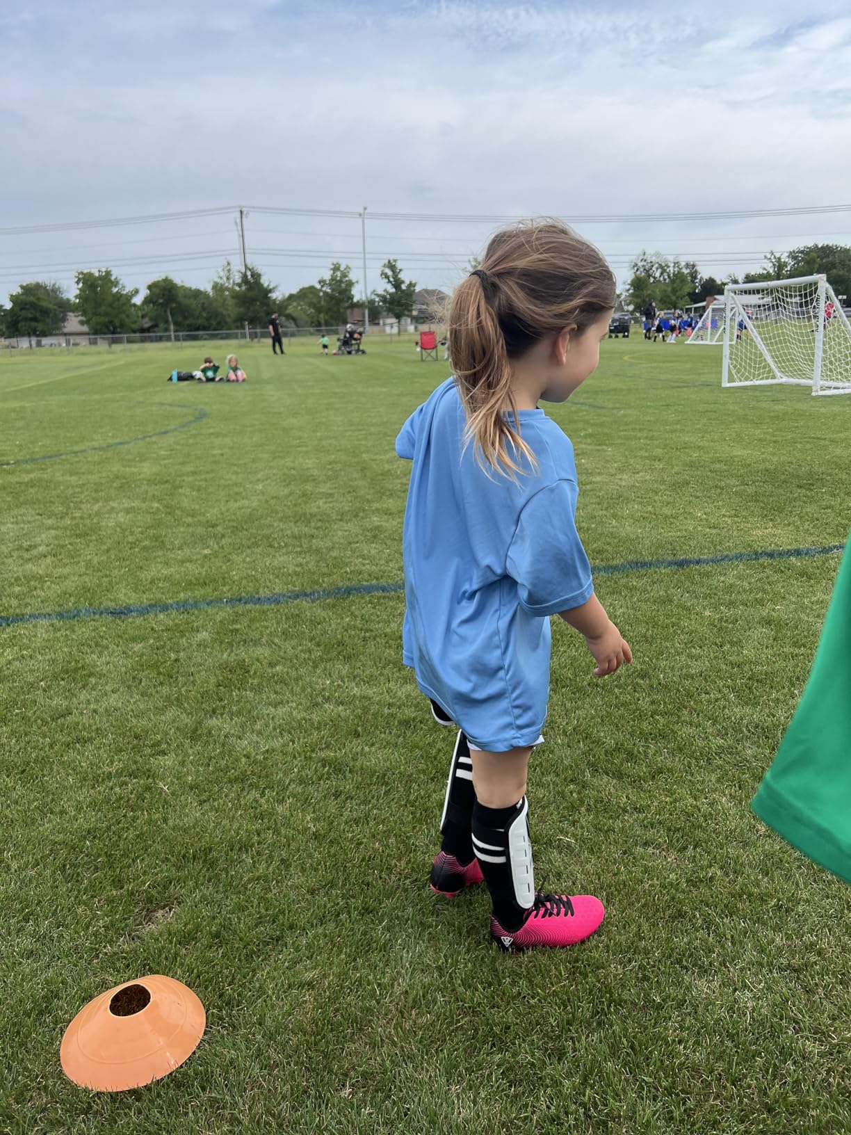Young player wearing lime green Vizari Stealth cleats during soccer practice on natural grass field